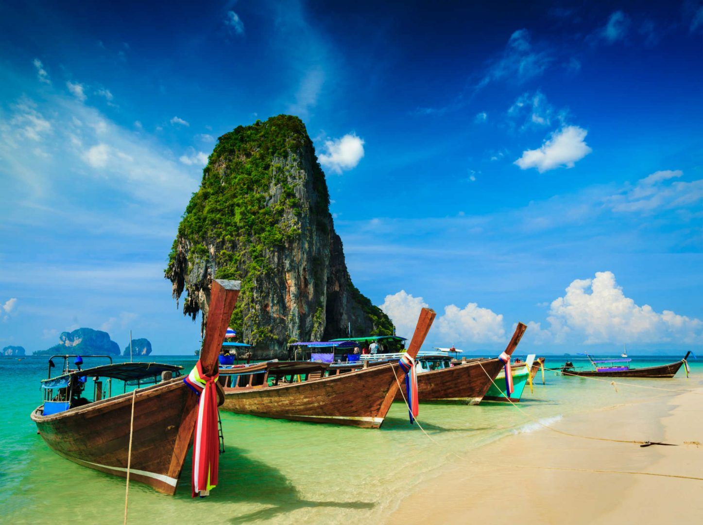 Long tail boat on tropical beach with limestone rock, Krabi, Thailand © Shutterstock